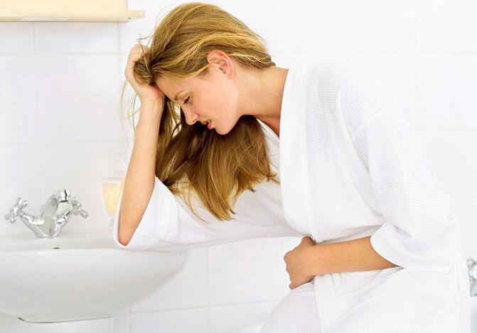 A woman is worried about the symptoms of cystitis in the form of frequent and painful urination